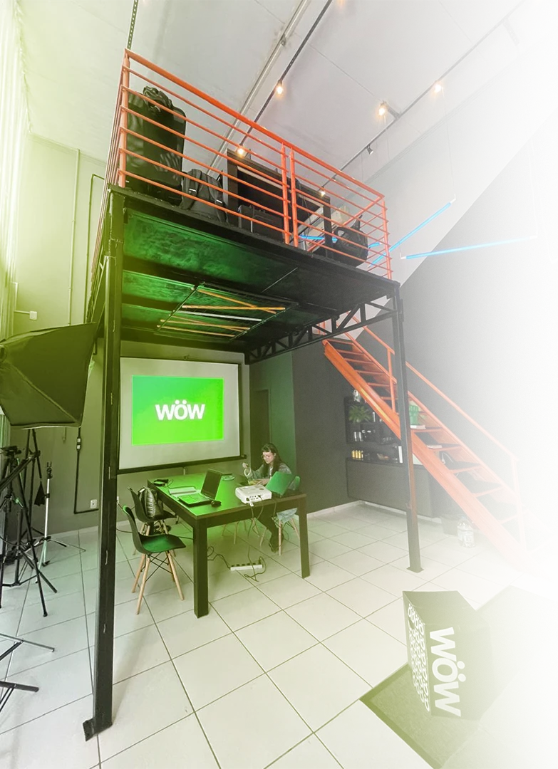 Interior do primeiro estúdio WOW, com mezanino e escada laranja
